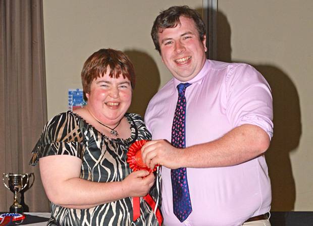 Robert McConnell receiving his prize for holding and restraining a calf section from Wendy Young